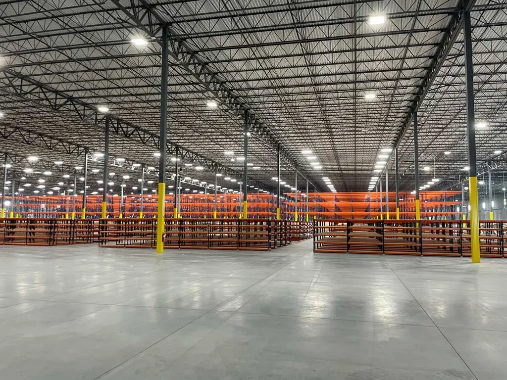 Large empty warehouse with shelving units.