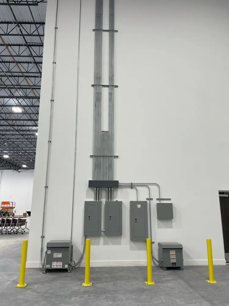 Electrical panels and conduits on wall.