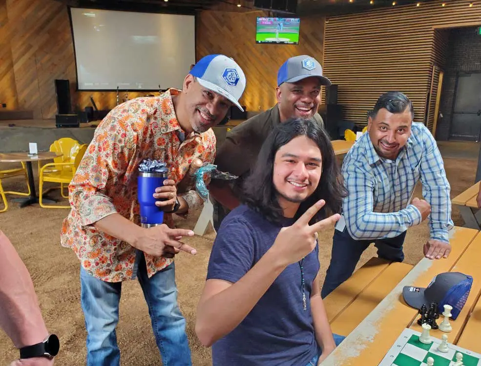 Four friends posing happily at a gathering.