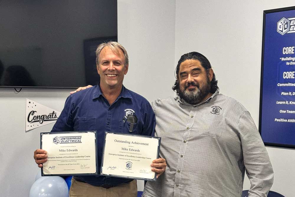 Two men holding certificates, celebrating achievement.
