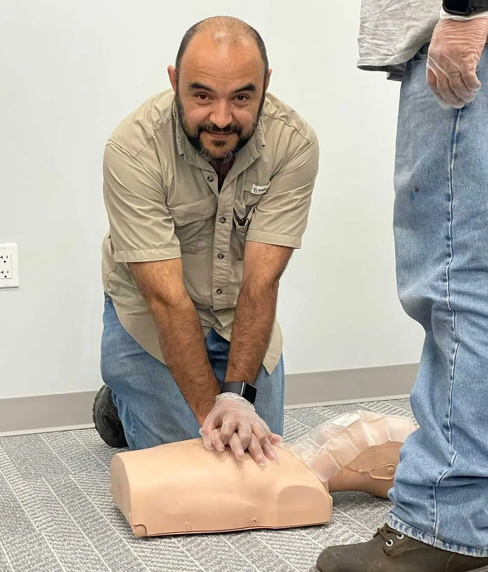 Man performing CPR on a training mannequin.