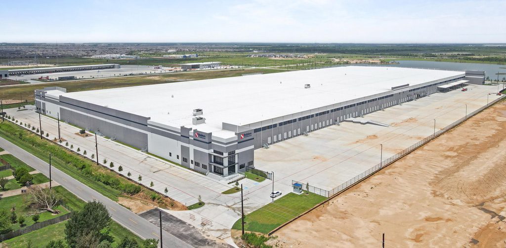 Large industrial warehouse with adjacent parking lot.