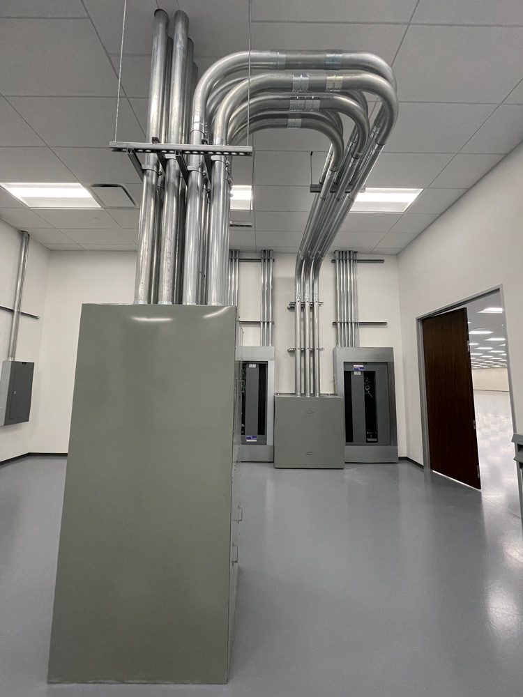 Metal pipes and electrical panels in room.