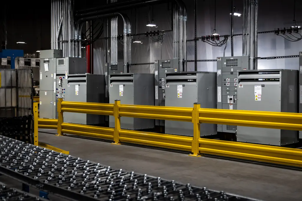 Industrial machinery lined against a yellow barrier.