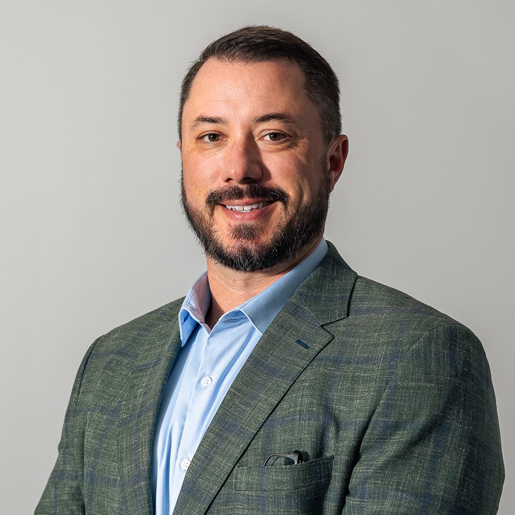 Bearded man in green blazer and blue shirt